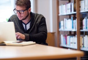 Young man working in library